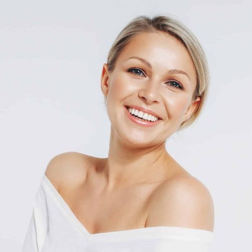 Beauty portrait of blonde smiling laughing woman 35 year plus clean fresh face isolated on white background